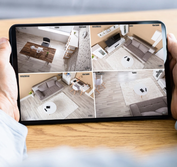 Personne qui tient une tablette avec des vidéos de sa maison